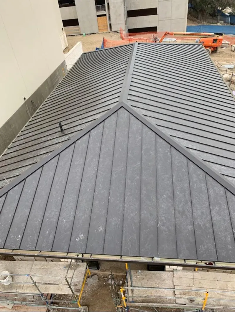 Commercial metal roof construction with crane equipment in Magna