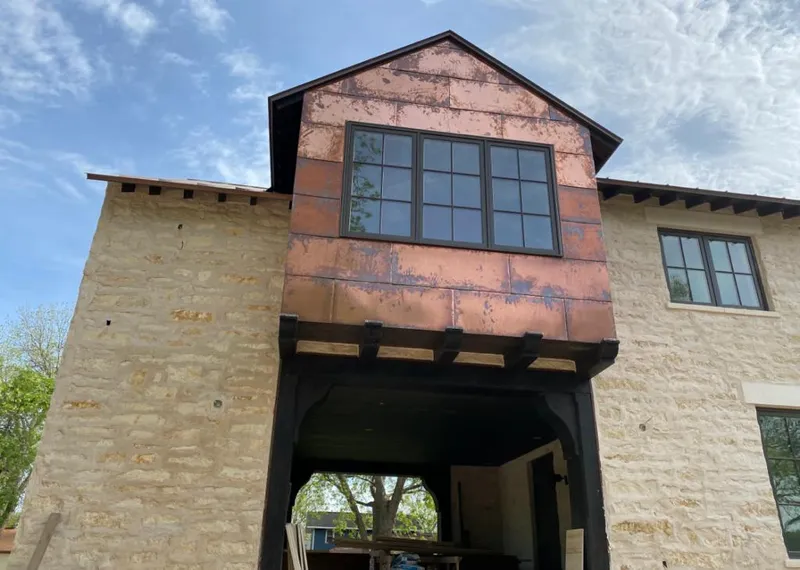 Copper metal panel facade on a stone building for Skylight Installation in Magna